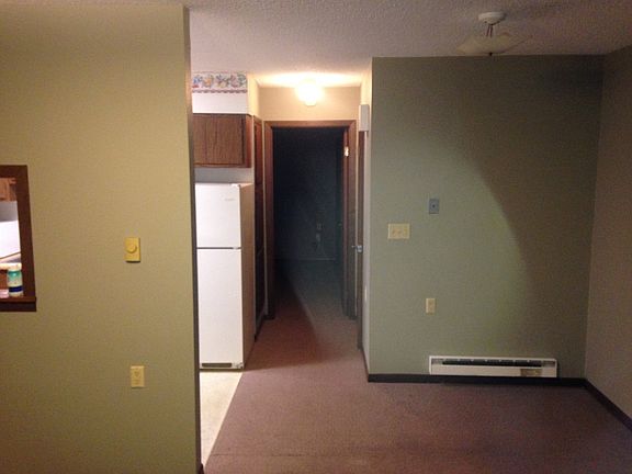 dining area on right, kitchen on left and hallway to bedroom