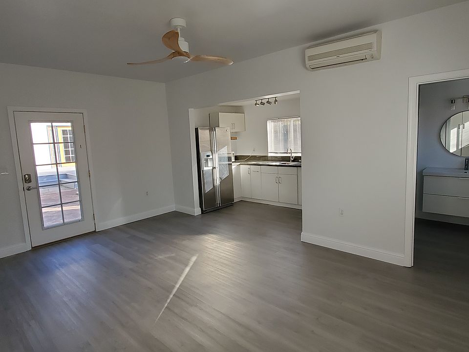 Open living/bedroom area with kitchen on left and bathroom entrance on right.