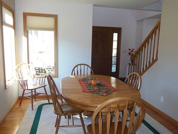 The dining room is adjacent to the entry and oak stairway leading to the upstairs bedrooms.
