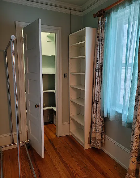 Step in large shelved closet, bookcase and wire rack for hanging clothes included in apt
