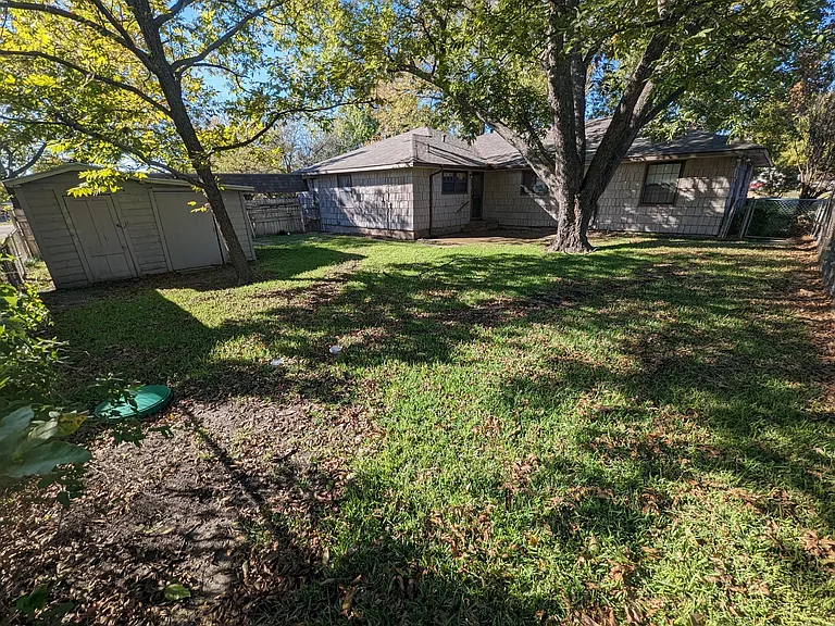 Back yard contains tool and garden shed