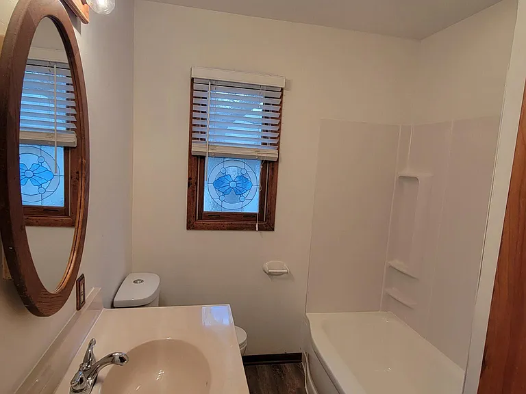main floor full bathroom with shower over tub & new vanity & LVP flooring