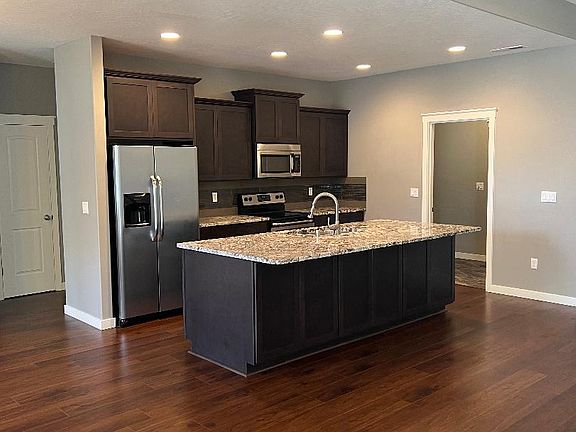 kitchen, with cabinets in front of the island for storage and large pantry adjacent to the kitchen