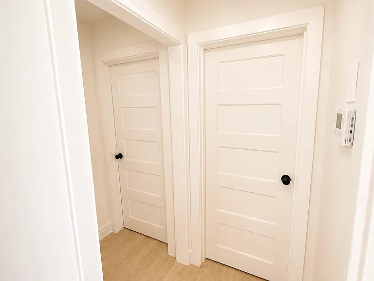 View of hallway with bedroom door (left) and bathroom door (right)
