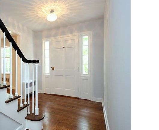 Foyer with Elegant Chrome and Crystal Lighting. Bunny Gray Walls, Bright White Trim & Beautiful Dark Walnut Stained Hardwood Floors Throughout!