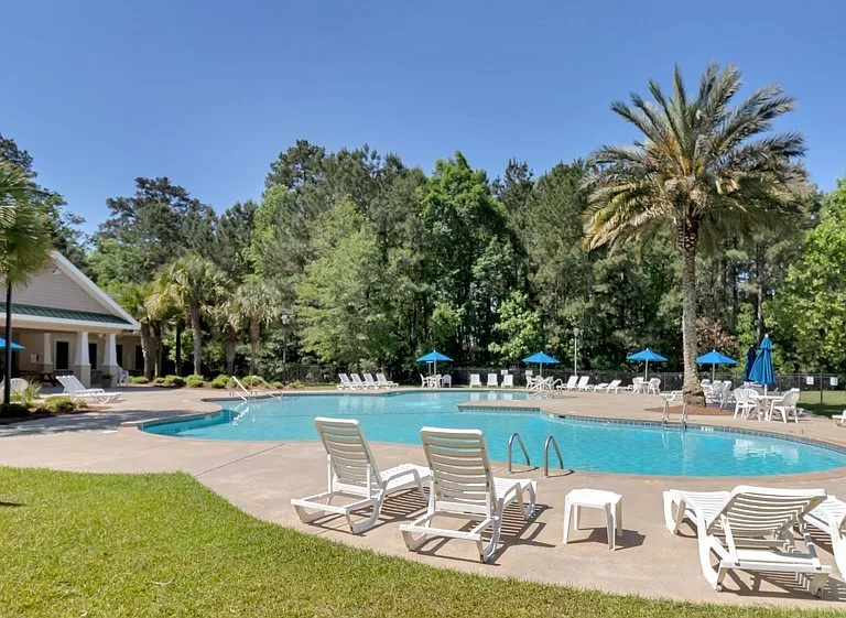 Spacious pool with picnic tables and lounge chairs