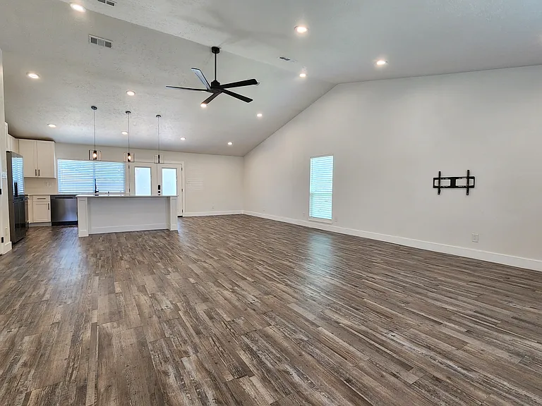 Living room open to the kitchen (includes TV mount)