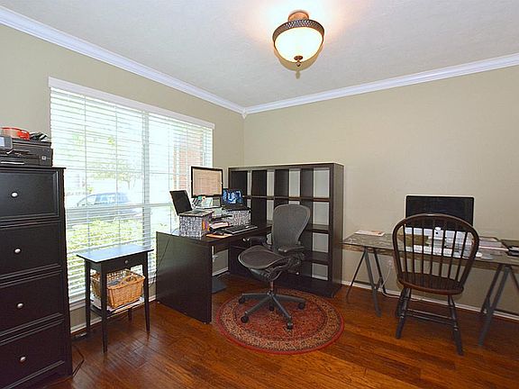Currently being used as an office, the formal dining room overlooks front yard. Notice the crown molding and floors