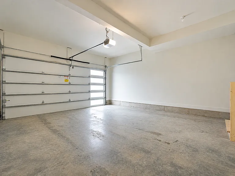 Oversized attached 2-car garage with high ceilings, additional storage space, and abundant natural light.