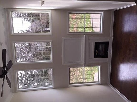 The Great Room is flooded with light!  It features a gas fireplace, hardwood flooring, and a ceiling fan.