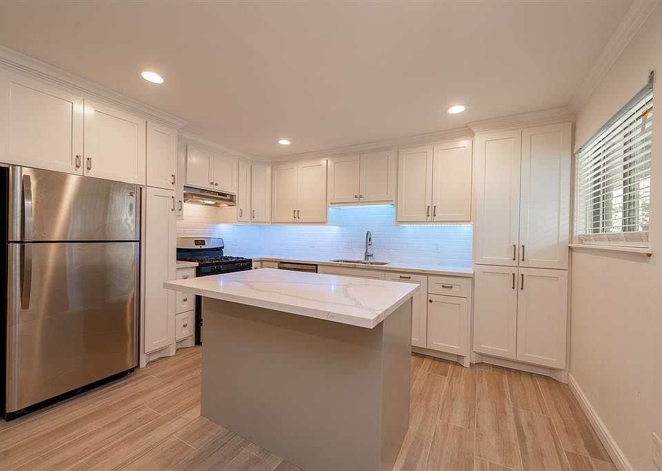 Completely renovated kitchen with stainless appliances, new cabinetry, beautiful backsplash, quartzite countertops, large island with storage underneath and beautiful lighting.