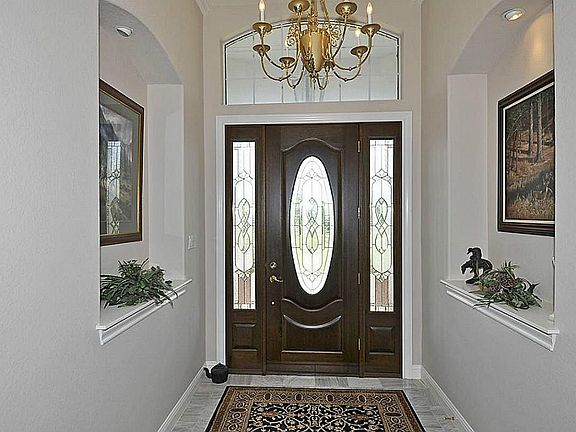  View from the inside while facing the front door.The foyer has high ceilings, crown molding, art niches and marble floors.