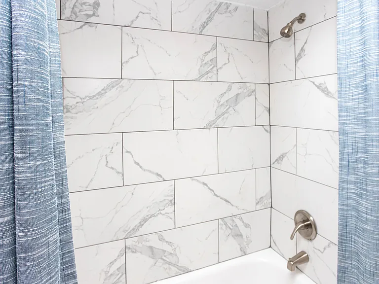 Bright bathroom with marble backsplash in shower