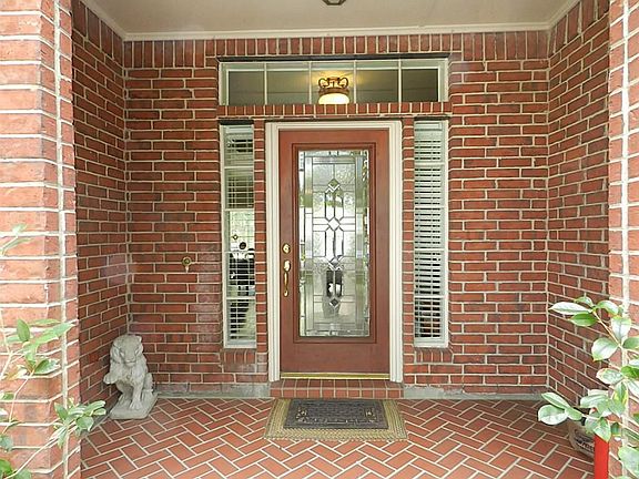 Spacious covered front porch to greet your guests.  Leaded glass mahogany door with side panel lighting and transom window.