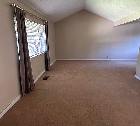 Living room with high ceiling adjoins the dining room area.
