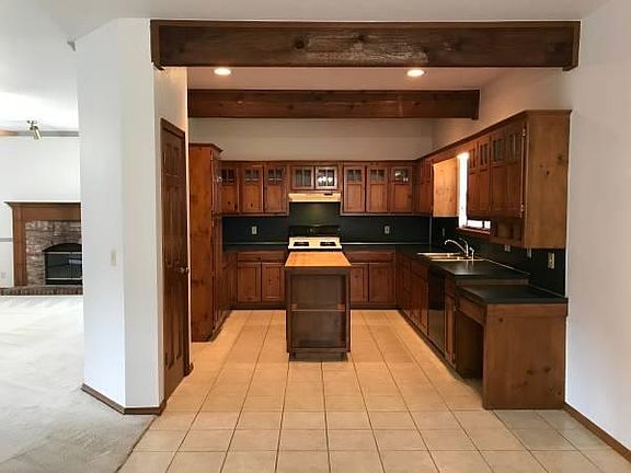 Kitchen with island, lots of cabinet space, desk area, and p
