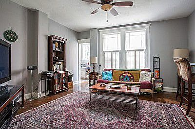 The living room features hardwoods, plantation shutters and 10 ft ceilings