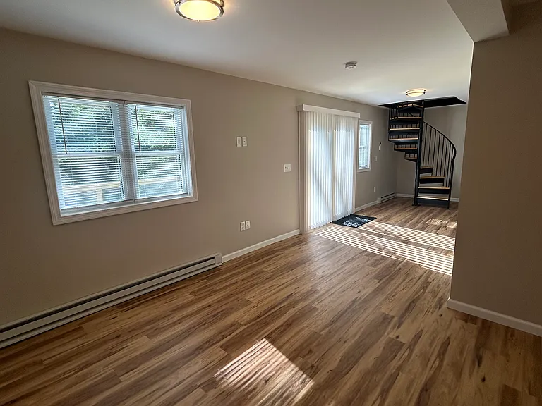 Lower level with sliders leading to expansive deck with sounds of the brook right outside your door