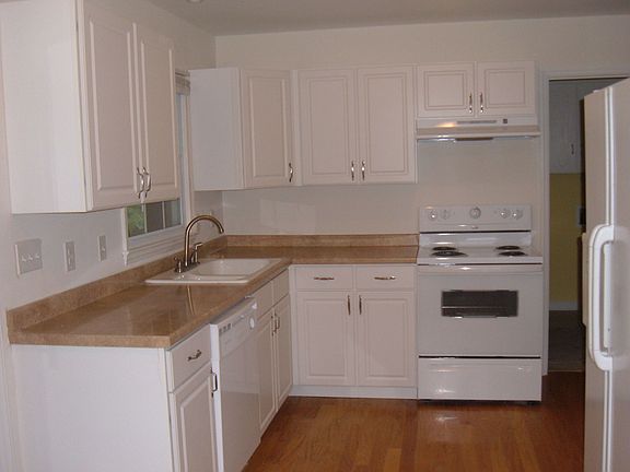 brand new kitchen with white cabinets, new counters & appliances