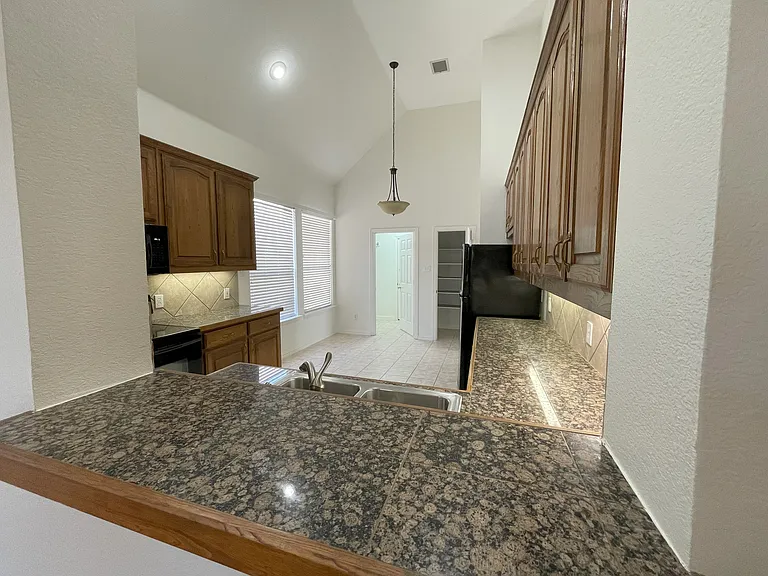 view through kitchen towards laundry room. Pantry visible beyond refrigerator