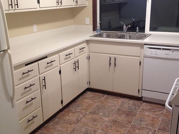 Kitchen with new quartz countertop, new linoleum floor, and repainted cabinets. Has fridge, stove, and dishwasher.