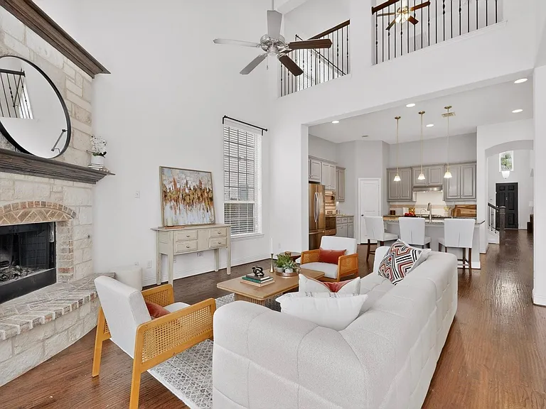 Bright living room showcasing a fireplace and a ceiling fan, creating a welcoming space.