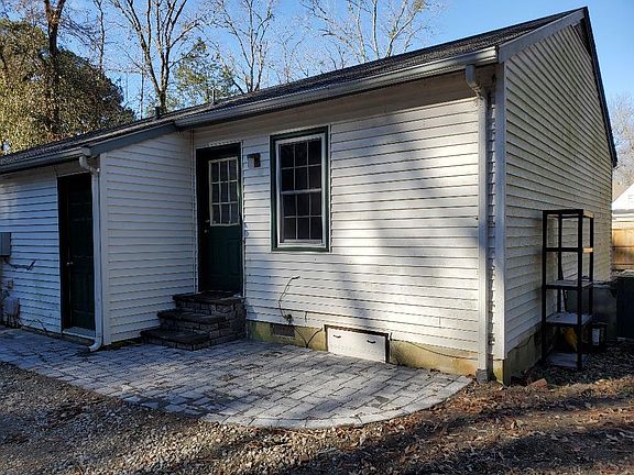 Back/Main entrance with new paved patio and steps. Door on left is laundry/utility room