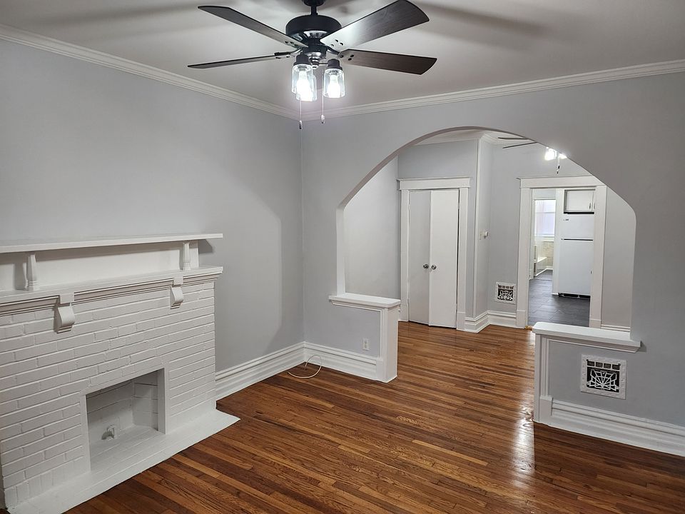 View from the front room looking into the middle room with hardwood floors, new ceiling fixtures and fresh paint.