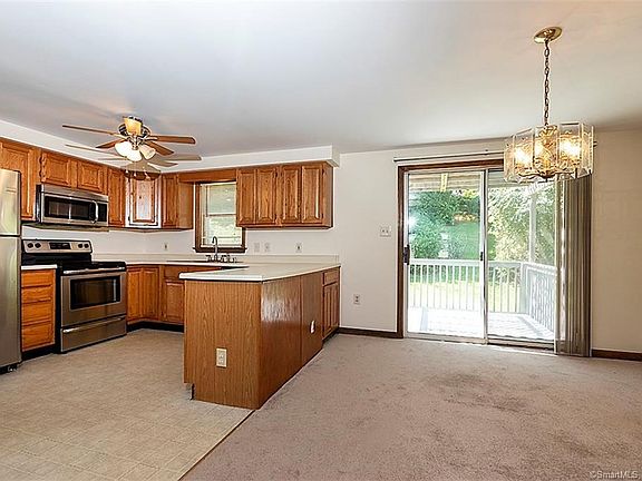 Modern open kitchen which opens to the dining area which leads through a sliding door to a private deck. The kitchen has stainless steel appliances (approximately 3 years old each) and vinyl flooring.