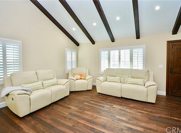 LIVING ROOM WITH RUSTIC HARDWOOD FLOORING, CUSTOM COLORS AND NEW WINDOWS AND TREATMENTS THROUGHOUT.