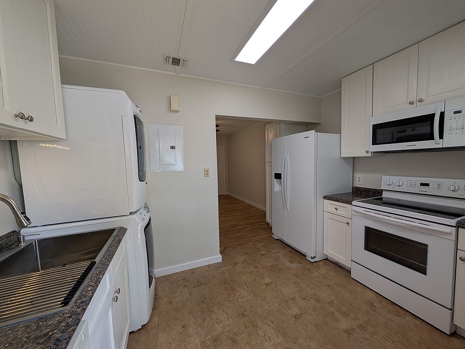 Kitchen featuring full size refrigerator, stove, dishwasher, microwave oven, washer & dryer and stainless steel single bowl sink.