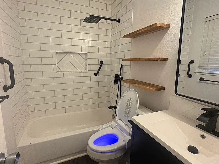 Remodeled Bathroom featuring a rainhead shower with handheld wand, stylish modern finishes, and a bidet toilet seat with seat warmer, wash, and dry functions.