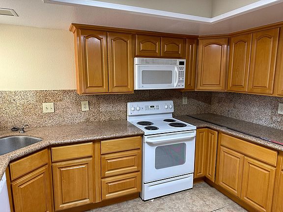 Large kitchen with plenty of cabinets with stove, microwave, dishwasher