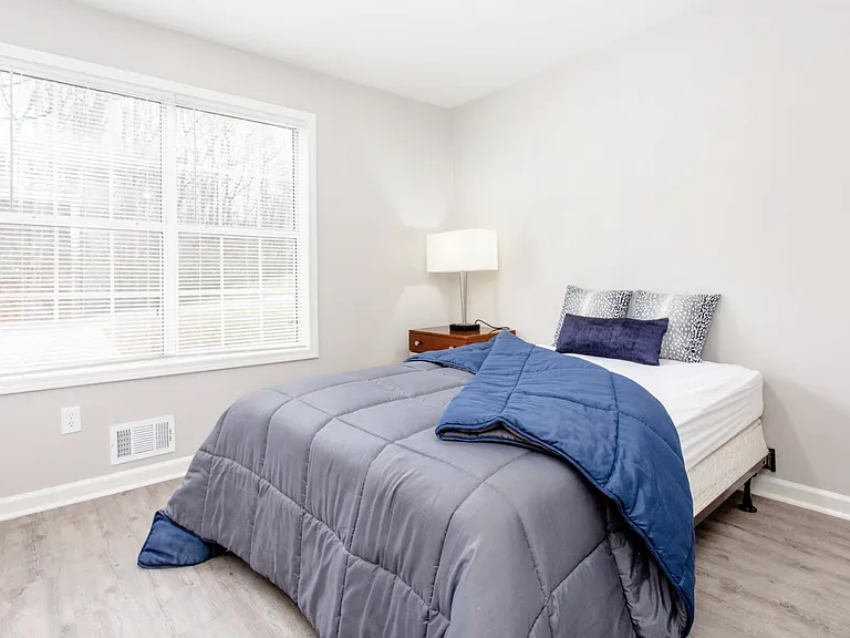 Bedroom with closet, nightstand and lamp.