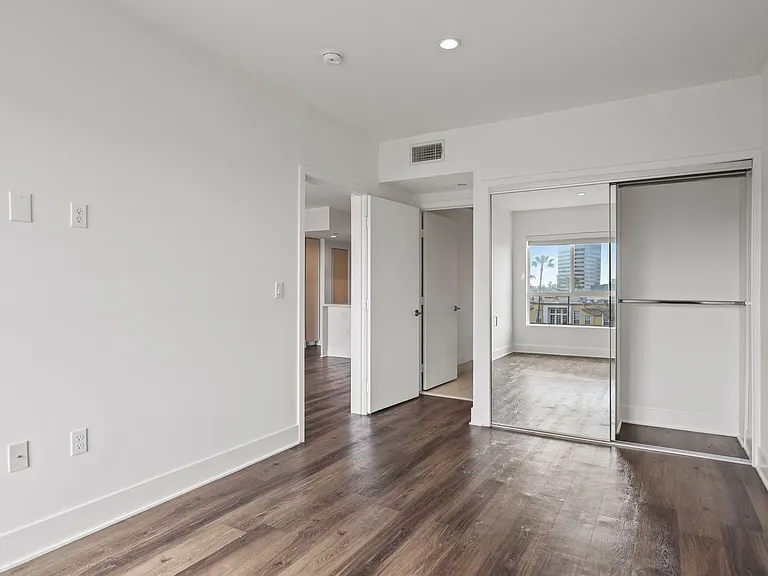 Bedroom with Mirrored Closet, Vinyl Flooring, and Recessed Lighting
