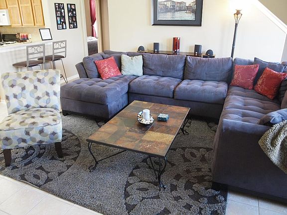 Kick back and relax in the family room with family and friends! Featuring crown molding, ceiling fan, corner gas log fireplace and tile flooring!