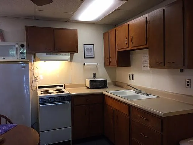 FULL KITCHEN SET-UP: RANGE W/ OVEN, FRIDGE, MICROWAVE, TOASTER OVEN AND DOUBLE BOWL SINK.