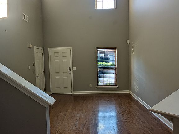 Living room view from kitchen facing front door and garage door into home