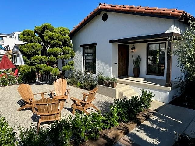 front of house, There is also a firepit and a dining table with benches not shown in this photo