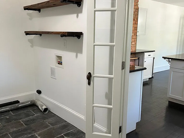 In-home laundry hook-up and shelving for storage.