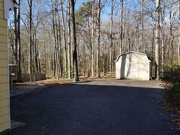 Rear view of large paved parking area - storage shed on righ
