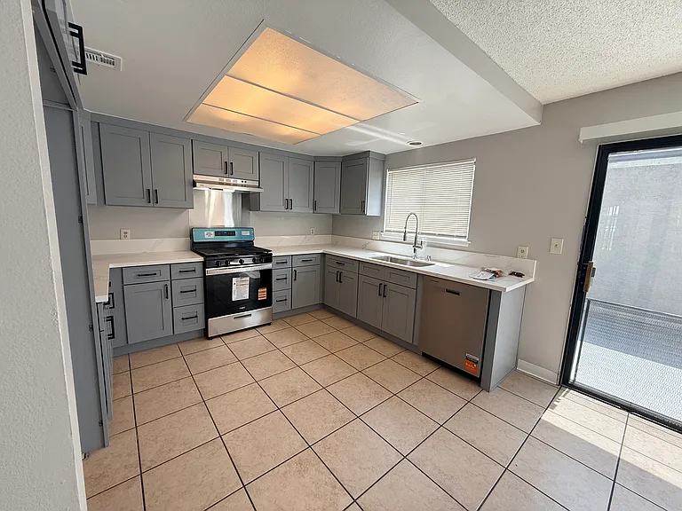 Kitchen has bright natural lighting and is conveniently adjacent to private patio and access to 2 car garage with laundry hook-ups