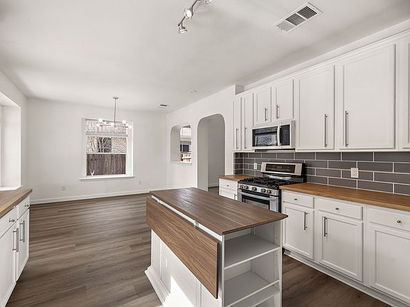 Chef's Kitchen: Island, Butcher Block Countertops, Modern Backsplash, Gas Cooktop, Modern Appliances, Walk-in Pantry. Separate dining area