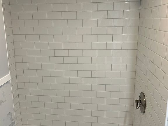 Subway tiled shower with tub