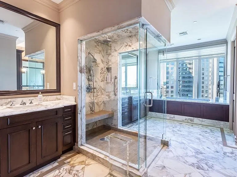 Oversized no-curb shower with dual heads separates the vanities.