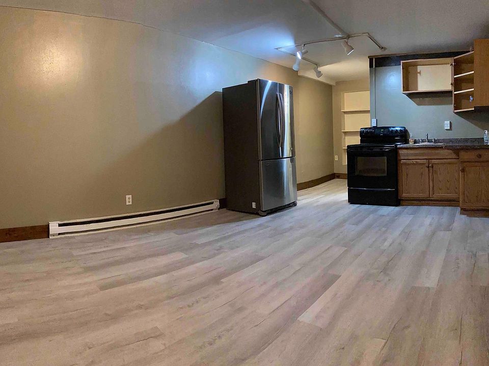 Wide-angle view of the living room, kitchen, and pantry space.
