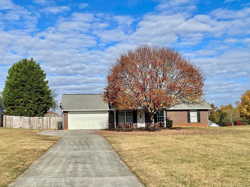 Front of House. Covered front porch, long driveway, large yard.