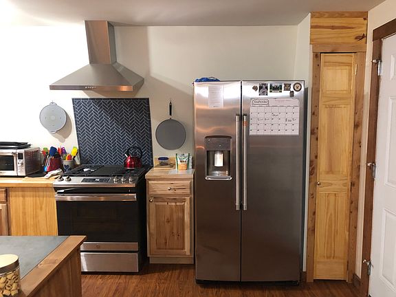 New propane range and new fridge. Fridge dispenses chilled water and ice. Mosaic herringbone backsplash on range.