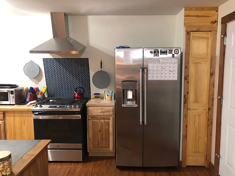 New propane range and new fridge. Fridge dispenses chilled water and ice. Mosaic herringbone backsplash on range.