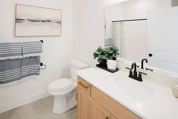 Staged photo. Condo has white cabinets with black hardware.